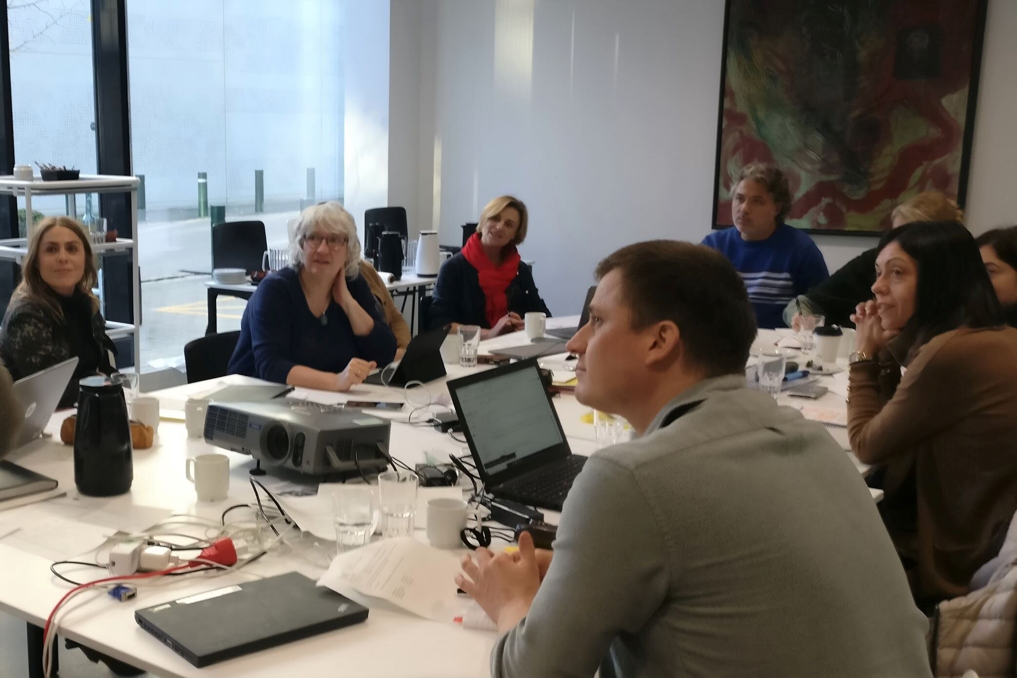 Deltagere omkring bord med computere